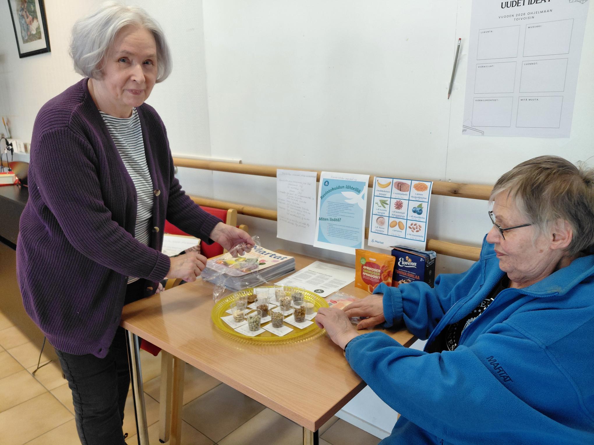 Marjatta Martikainen ja Riitta Lehikoinen asettelivat infopisteen materiaaleja Ellinkulmalla tiistaina. Infopisteet ovat näkyvillä perjantaihin.  