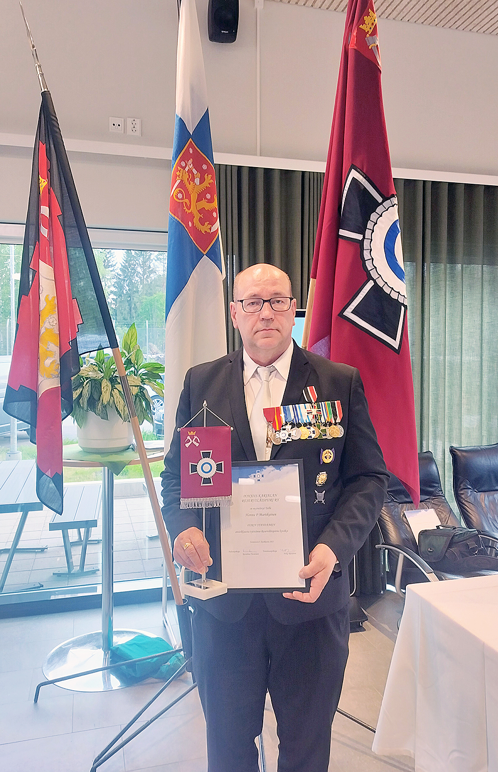Hannu P. Martikainen palkittiin reserviläisten ylentämistilaisuudessa reserviläispiirin standaarilla.