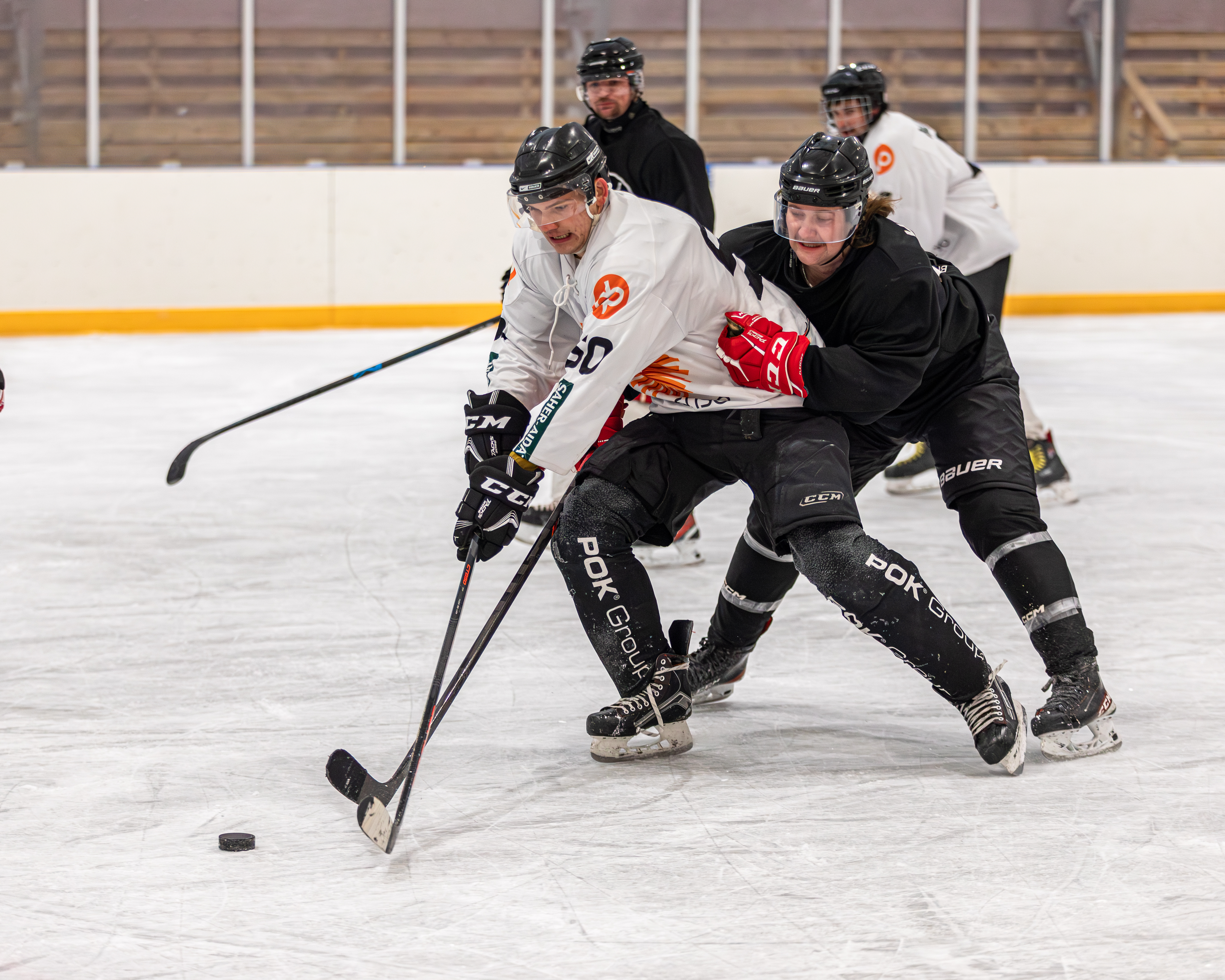 Valkeapaitainen JuPsin pelaaja Ohto Repo väänsi kotiturnauksessa Vilttiketjun Jonne Vilhosen kanssa. Kuva: Teemu Mustonen.