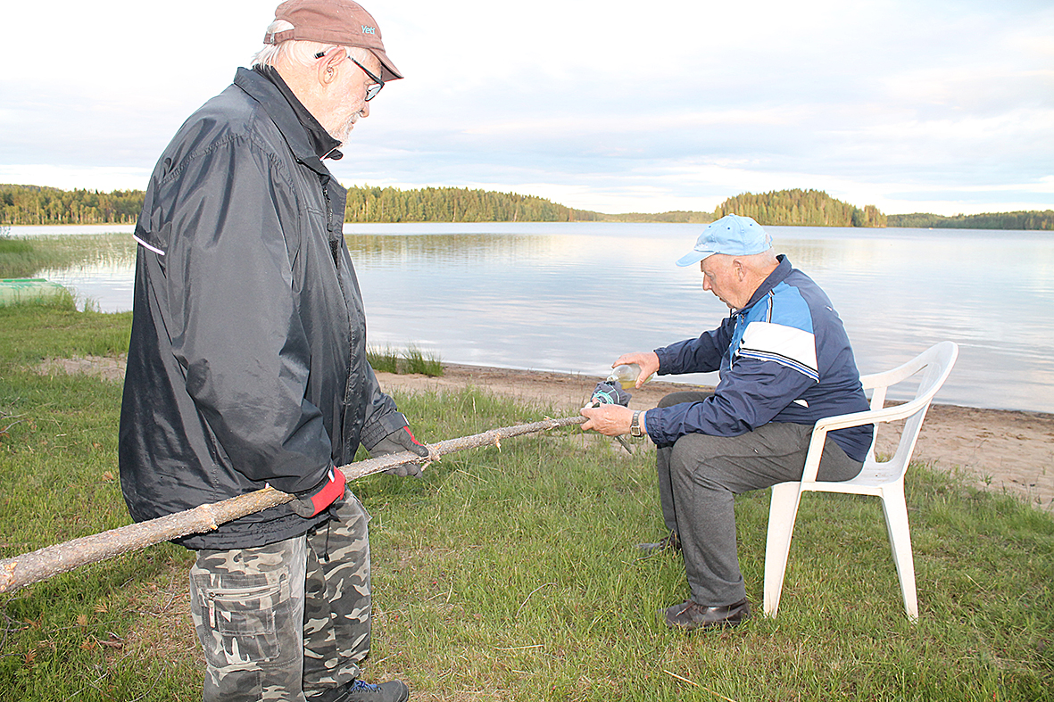 Kohta syttyy kokko. Ensio Koliseva piteli puukeppiä. Esko Nykänen valeli kepin päässä kiinni olevan vaatekappaleen bensalla.
