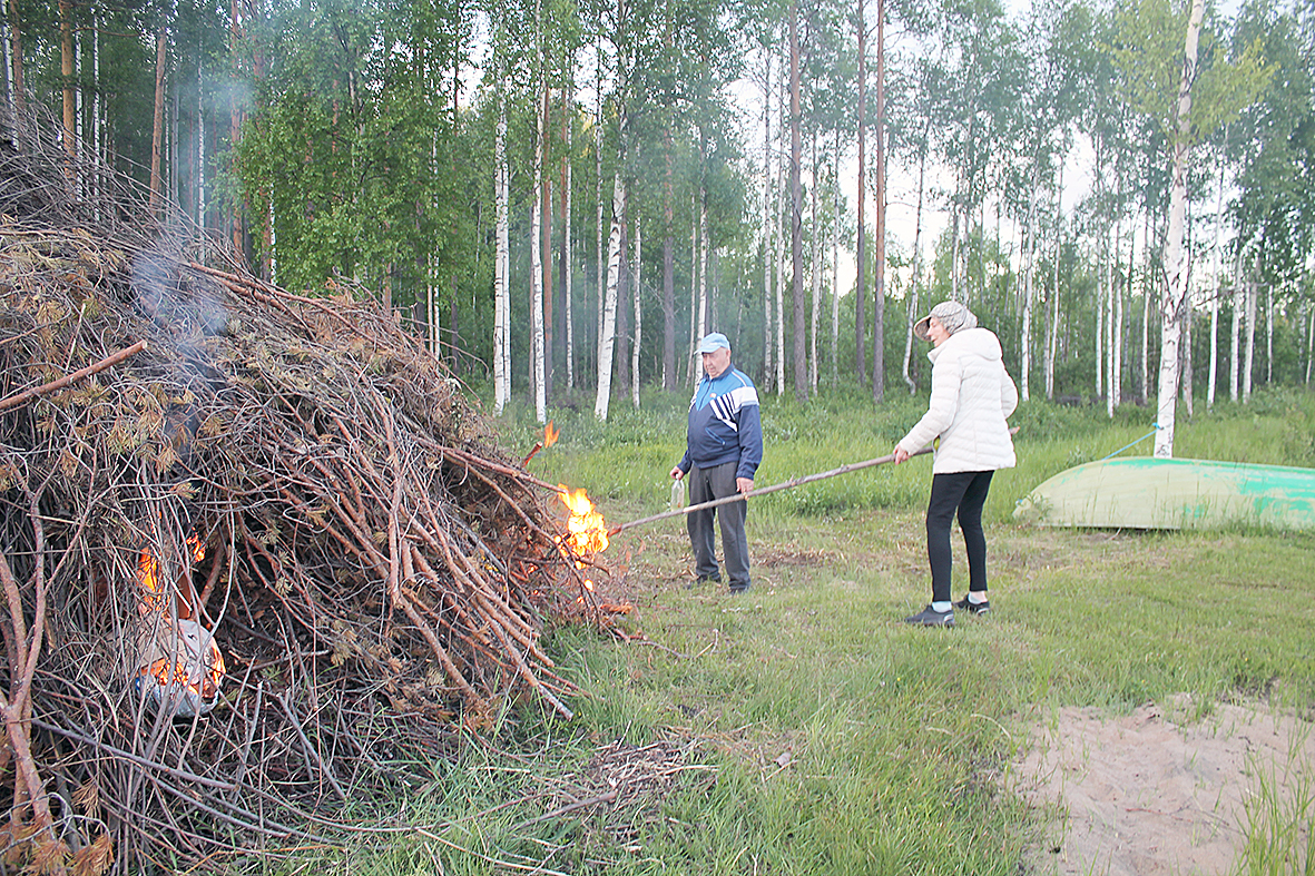 Tositoimissa. Esko Nykänen ohjeistaa Irma Toivasta juhannuskokon sytyttämisessä.






