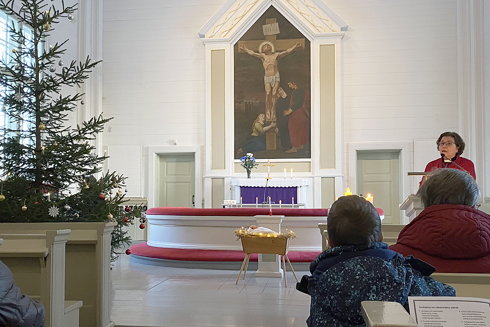 Laulamisen lomassa Elisa Hietaharju ohjeisti lapsia muun muassa koristamaan kirkkoa kynttilöiden loisteella ja kuusen palloilla sekä peittelemään kaukalossa lepäävän vauvan. 