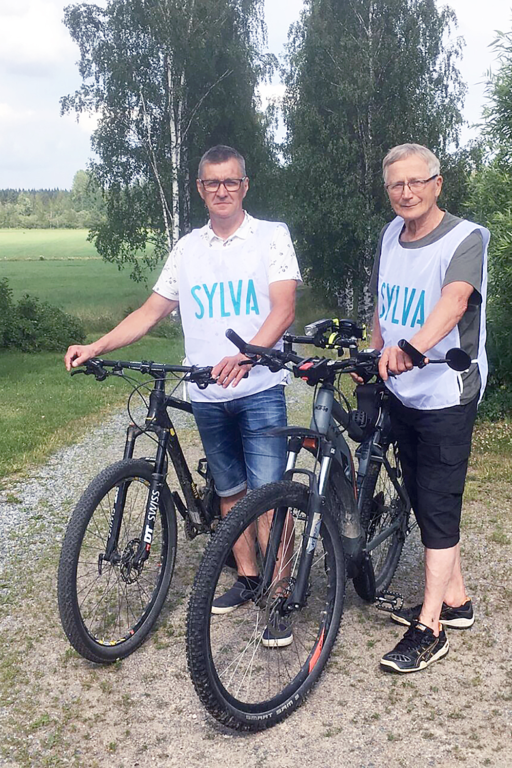 Syöpäsykkelin isät Matti Kumpulainen (oik.) ja Kari Saastamoinen tuovat elokuussa hyväntekeväisyyspyöräilijät Lieksan Rukajärvikeskukselle ja vievät heidät edelleen Pielisen yli Kolille. 
