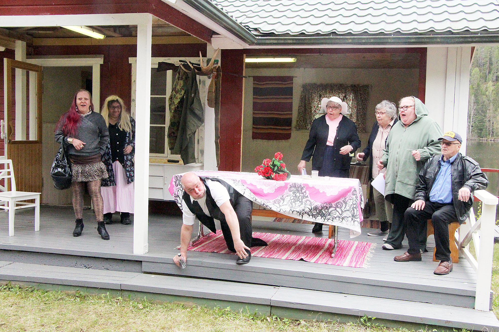 Akkarallia Vuokonjärvellä. Mervi Ala (vas.), Armi Timonen, Eija Meriläinen, Ritva Väyrynen, Lea Nykänen ja Raimo Ahonen ihmettelevät Jani Karppisen näyttelemän Veijon ilmestymistä pöydän alta. 
