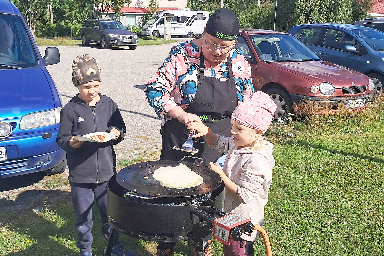 Eevi ja Eemeli Hiltunen paistoivat lettuja Jaana Tiaisen opastuksella.