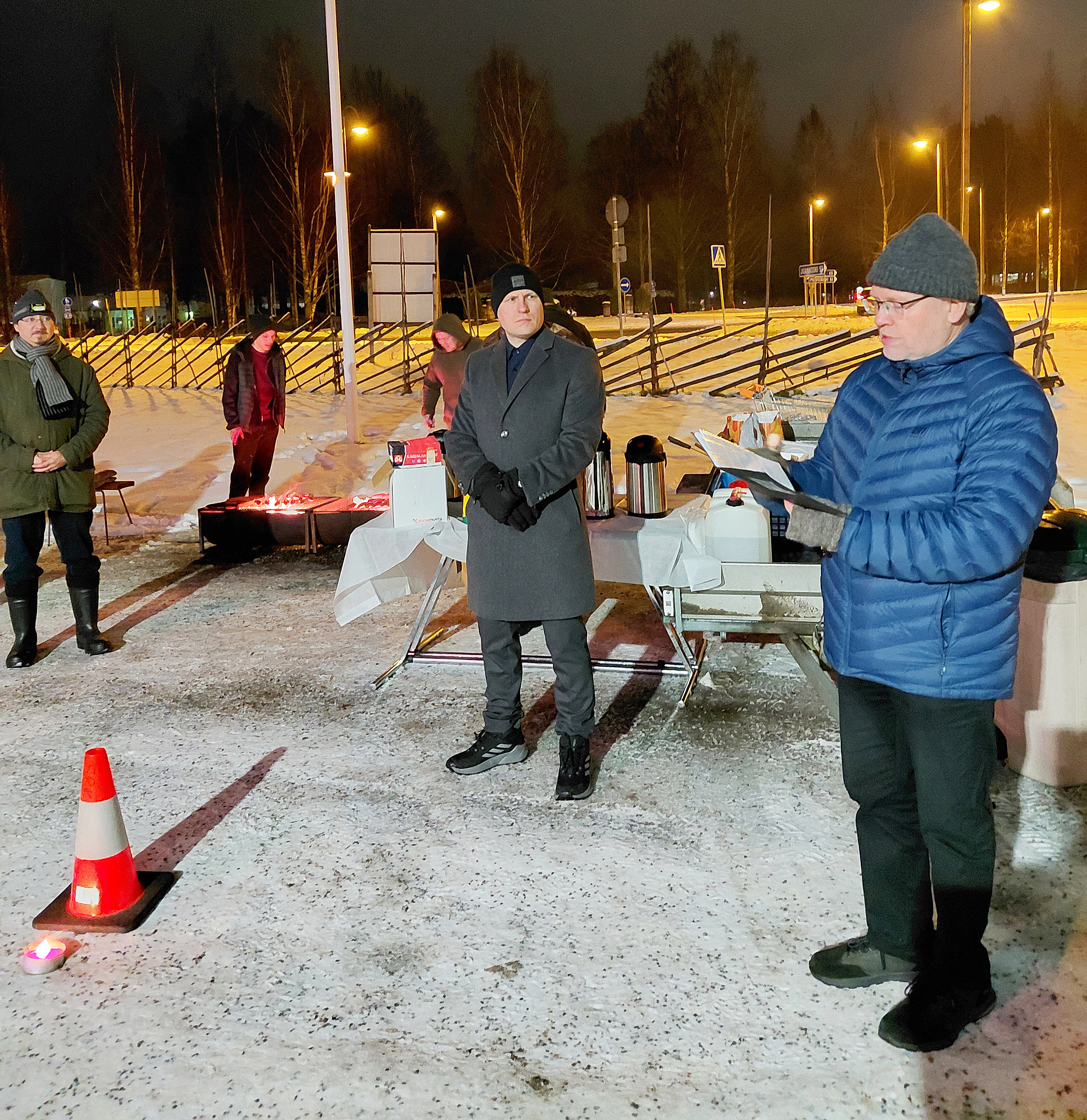 Juuan kunnanjohtaja Henri Tanskanen (vas.) kuunteli kirkkoherra Mikko Huhtalan puhetta Reserviläisten joulutulilla. Takana äärimmäisenä vasemmalla Juuan Reserviläisten sihteeri Miikka Rissanen. 