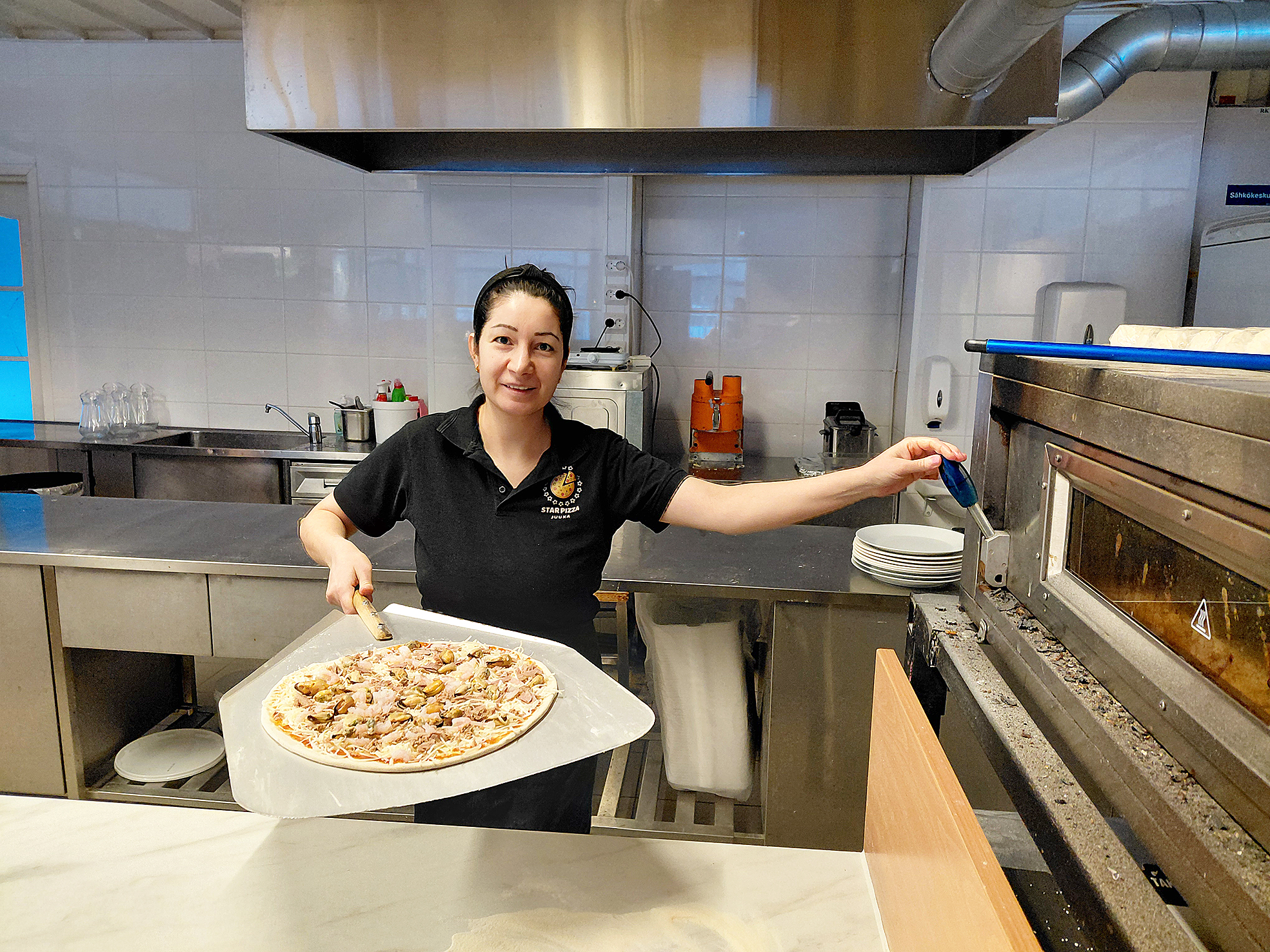 Pehmeä taikina vaatii ammattitaitoa ja nopeita käsiä, jotta pitsa päätyy uuniin eikä tartu lapioon.
