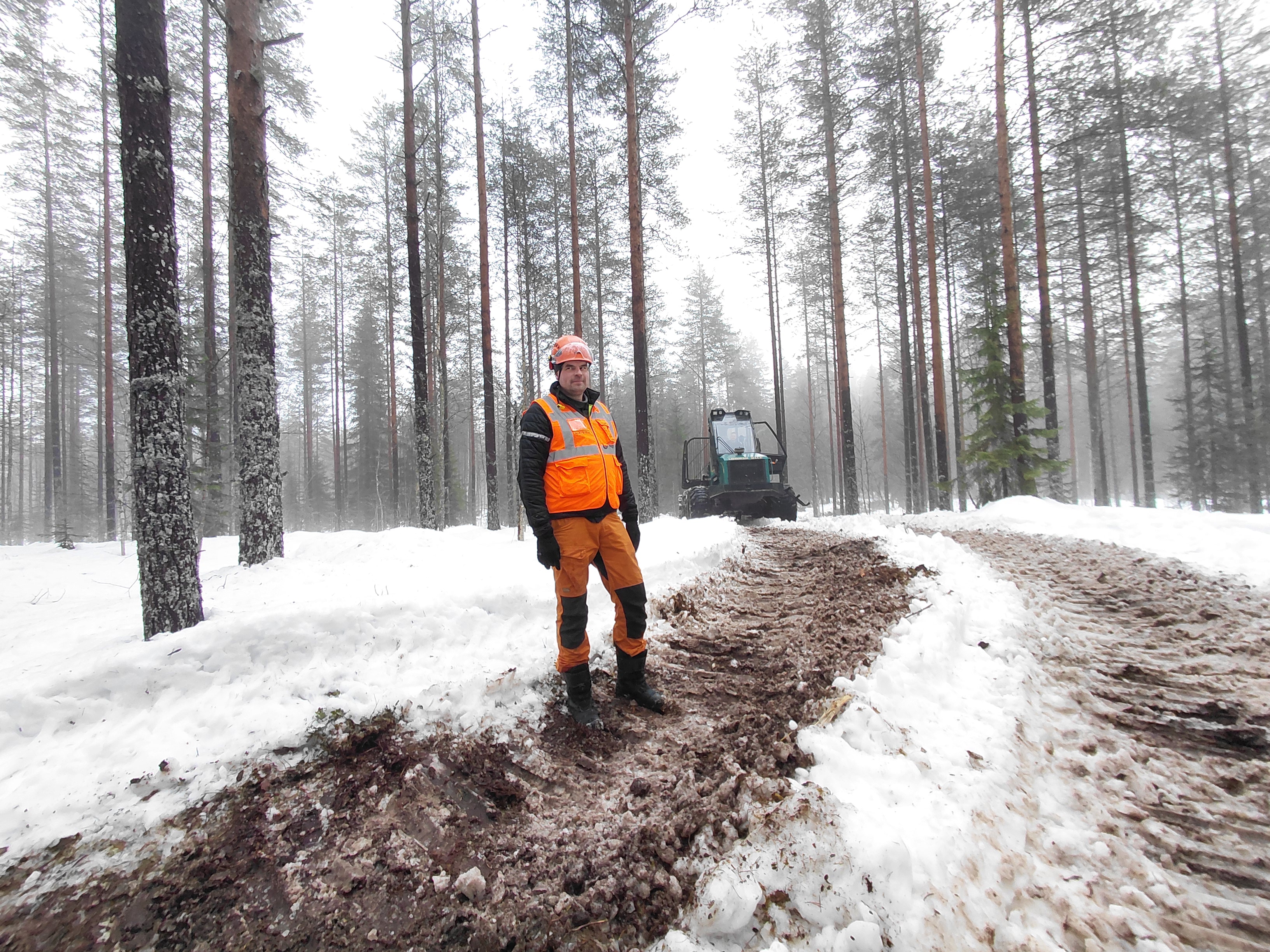 Ajokone tuo moton korjaamat puut tien varteen. Risto Keskinen näyttää, mistä kohti maasto alkaa jo pehmetä. 

