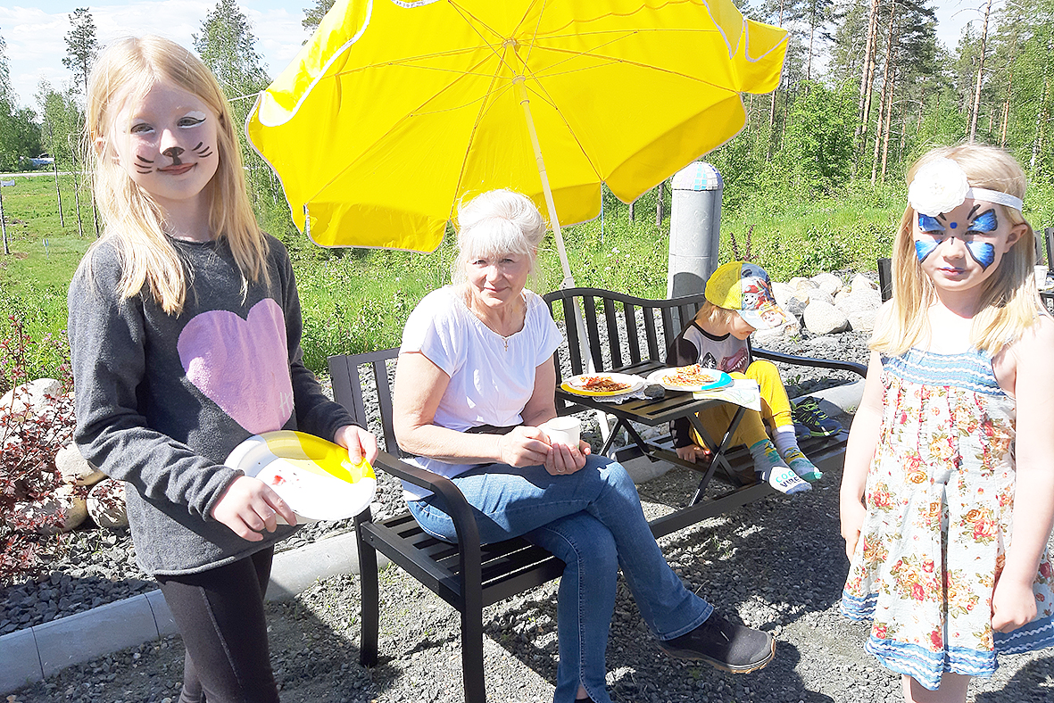 Herkuttelua ja kasvomaalausta. Vohvelit maistuivat Marja Urpaselle (keskellä) ja hänen lapsenlapsilleen Ninnille, Iidalle ja Julius Soiniselle.