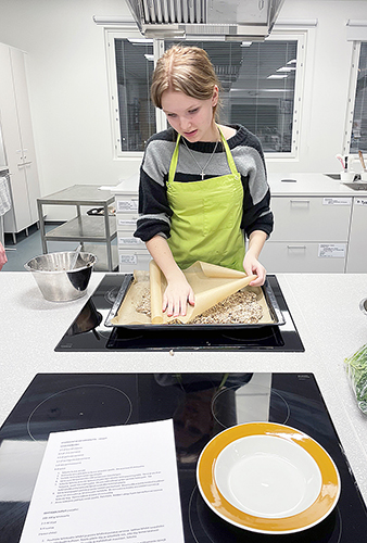 Yhdeksäsluokkalainen Veera Lammin tekemässä siemennäkkileipää Hyvinvointia vatsan kautta -pajassa.