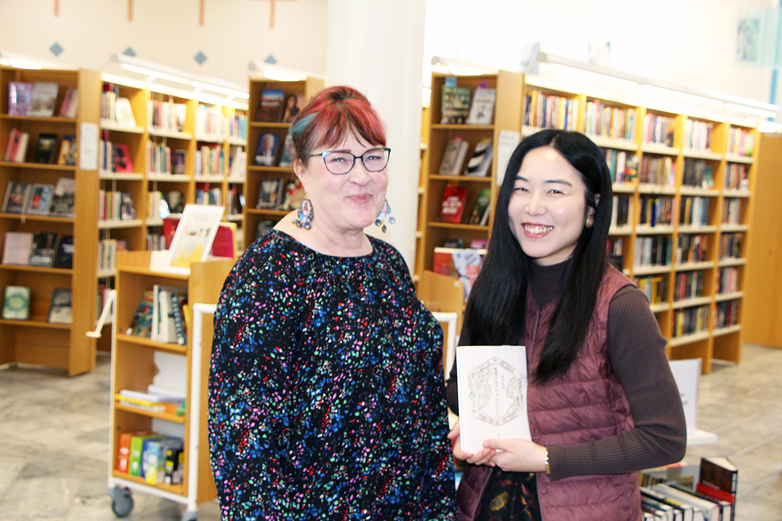 Yumi Tanaka luovitti väitöskirjansa Juuan kirjaston Iina Aaltoselle. 
