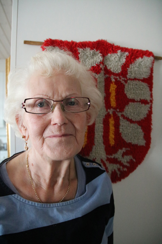 Anna-Liisa Hyykyn yksi mieliharrastus ovat olleet käsityöt. Taustalla oleva kangasvaakuna on yksi taidonnäytteistä.