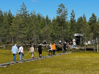 Kirkkokansa kulki uudistettuja pitkospuita pitkin Mataran hetteikön yli kuulemaan jumalansanaa.