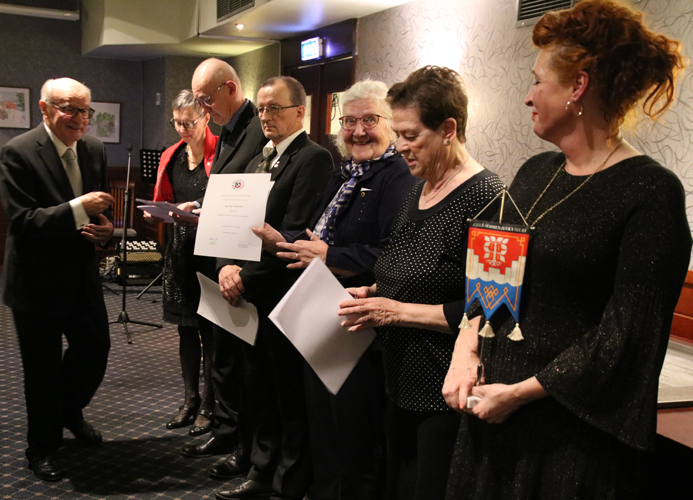 Etelä-Suomen Juuka-Seuran kunniapuheenjohtaja Yrjö Puoskari jakoi huomionosoitukset ansioituneille ESJS:n jäsenille. Marja-Leena ja Jarmo Vepsäläinen (takana), Pauli Halonen, Inge-May Lehikoinen, Kaija Turunen sekä Kirsi Pääskyvuori huomioituina.