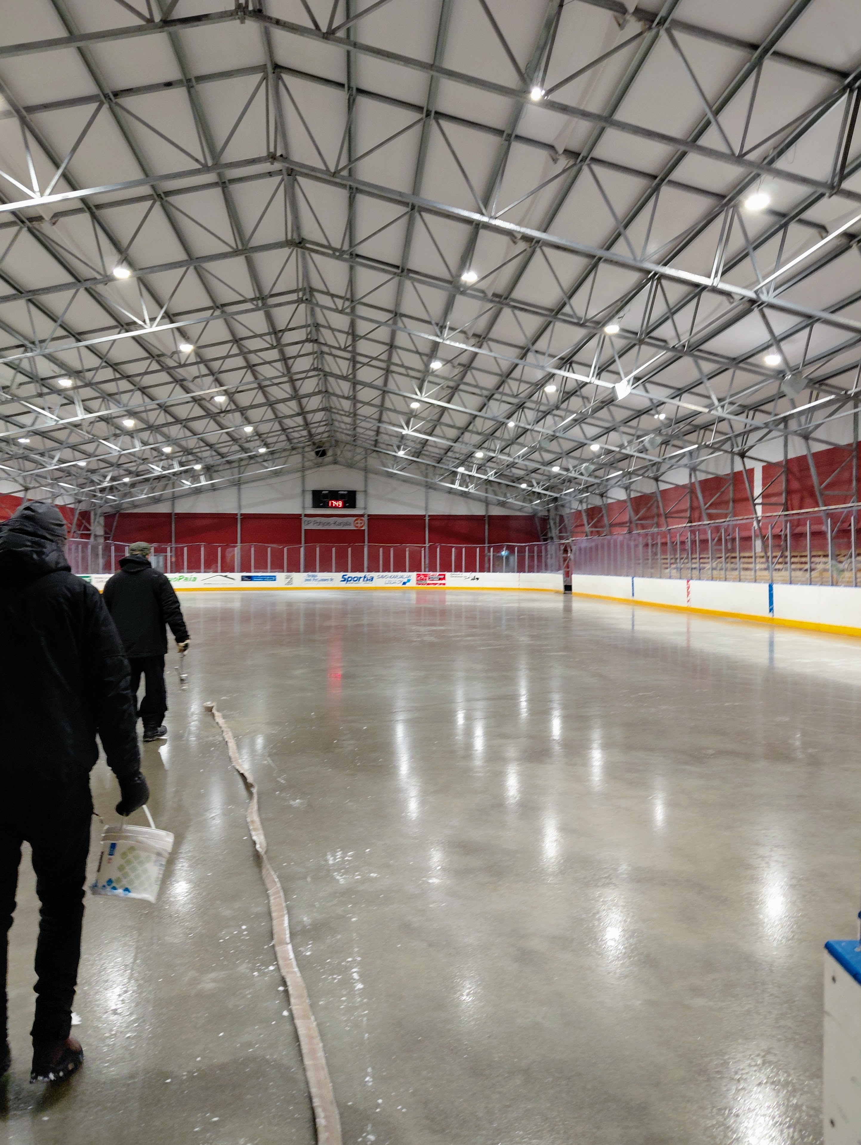 JuPSin Jarmo Martikainen ja Jukka Parikka toivovat pakkasia, jotta saataisiin jää valmiiksi innokkaille pelailijoille. Kuva: Minna-Liisa Riestola