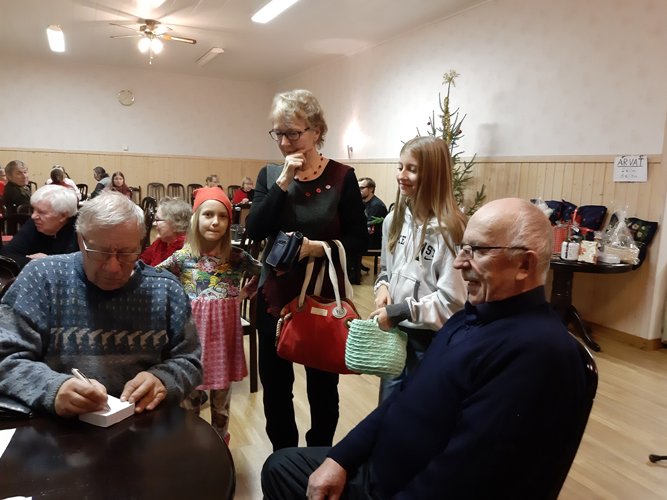 Seija Brelo myi arpoja lastenlastensa Elsa ja Erika Brelon kanssa.