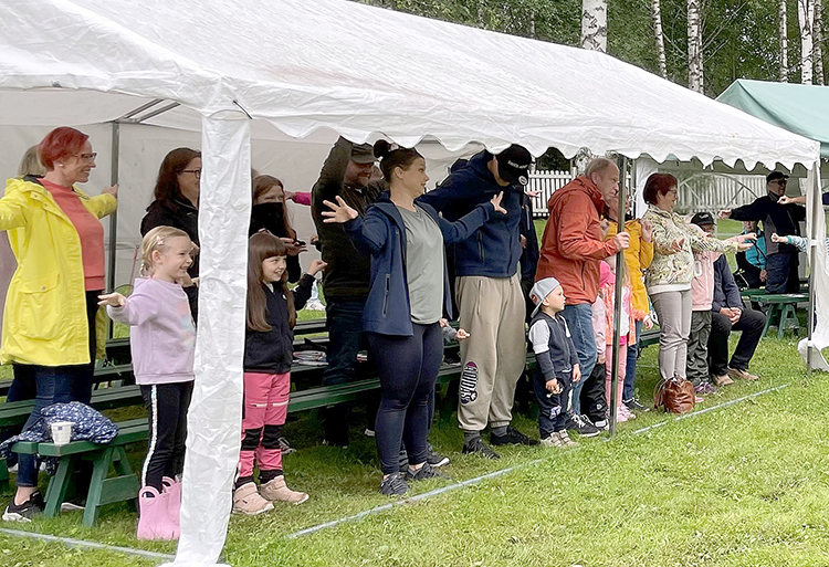 Sadekaan ei haitannut, kun yleisö jumppasi Rölli-jumpan tahtiin katoksen alla. 
