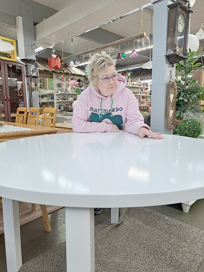 Jaana Plattonen tarkastelee edellisviikolla maalatun pöydän pintaa. Pöytä kelpaa ehostettuna uuteen kotiinsa. 