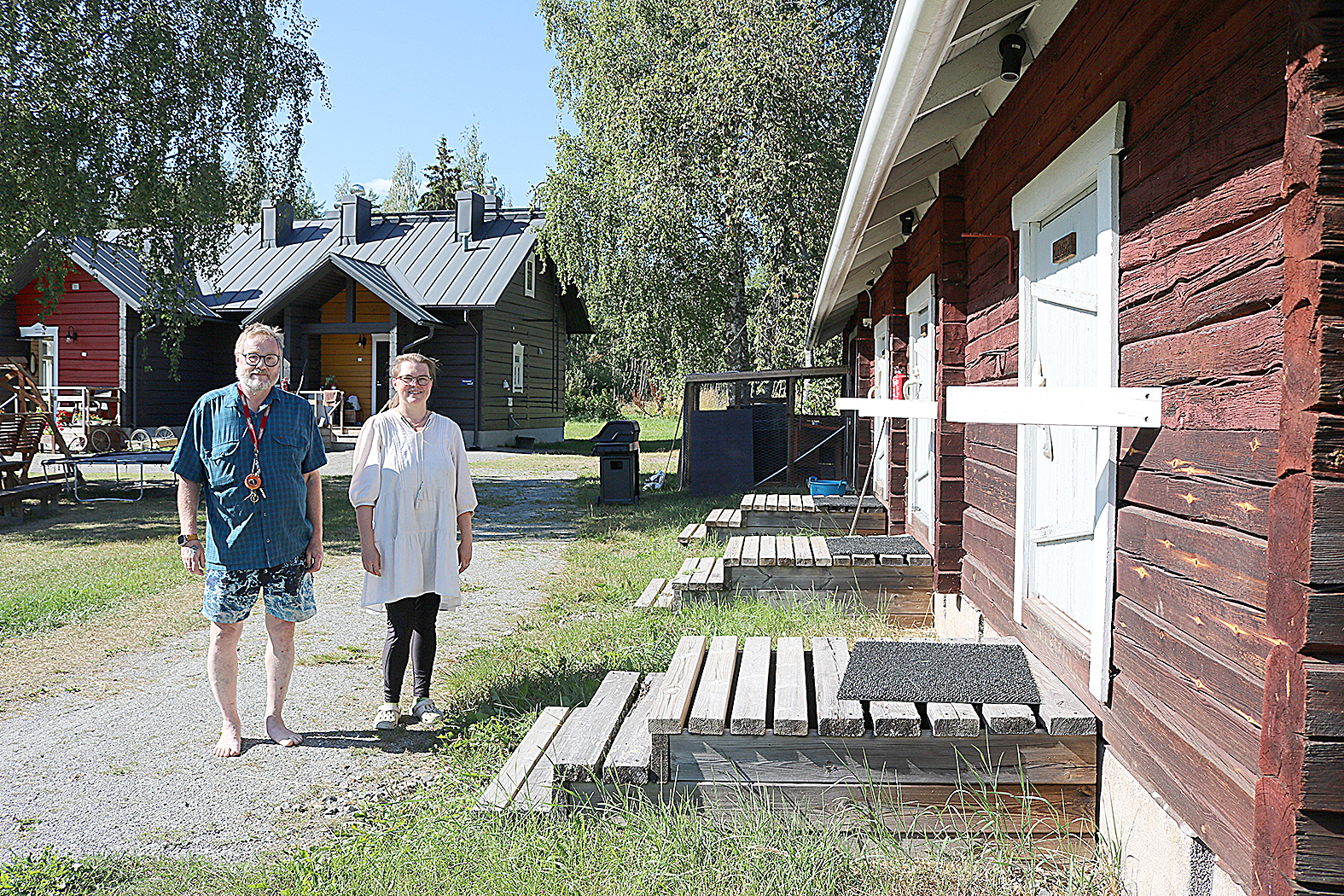 Pekka Ahlholm (vas.) ja Kaisu Kantelinen Kiviniemen retkeily- ja matkailutilan pihapiirissä, joka on kuin suoraan vanhoista Suomi-filmeistä.
