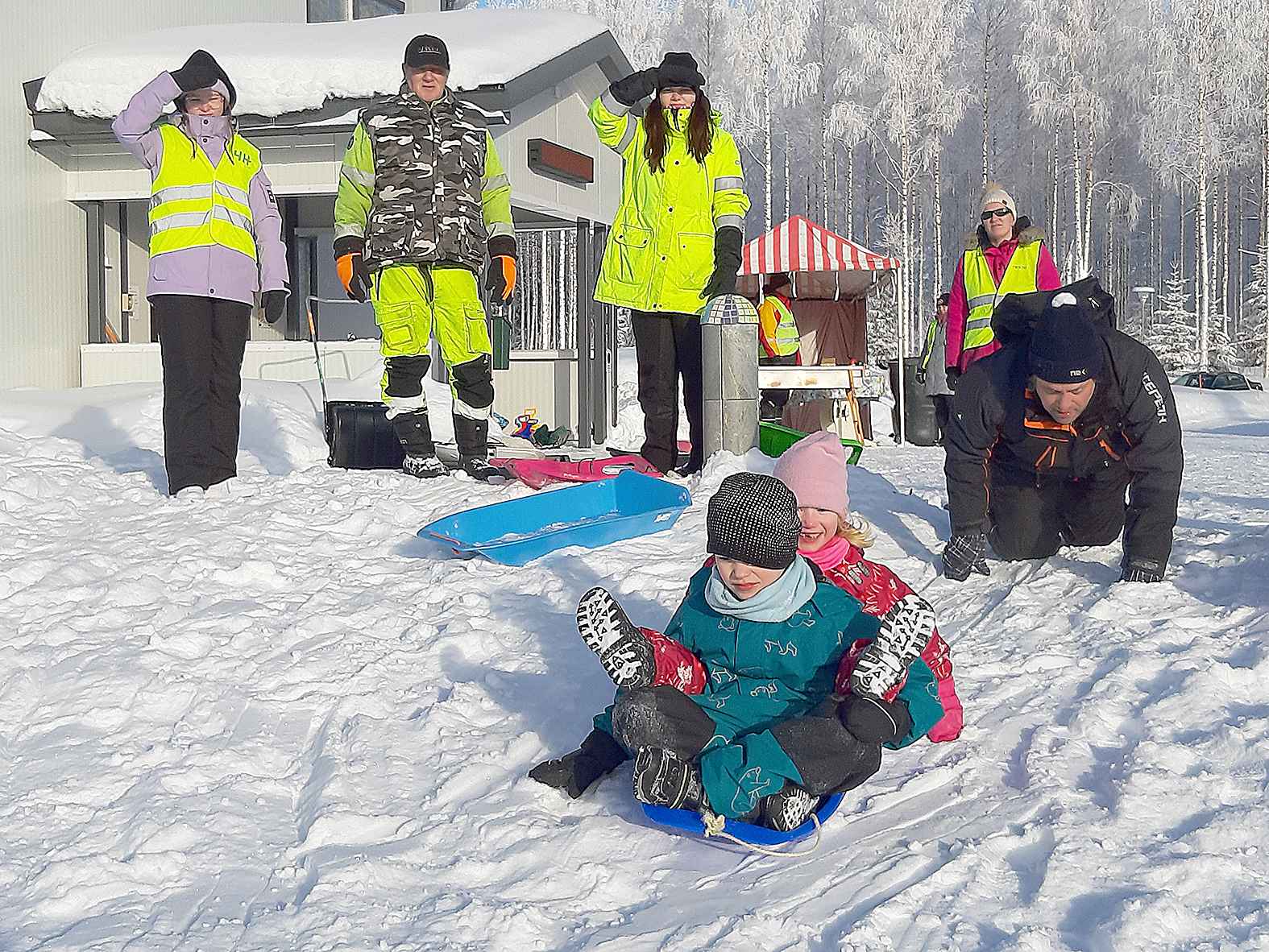 Lasten oli mukava lasketella, kun Matti Lehikoinen (toinen vas.) oli tehnyt hyvän mäen Monikäyttötalolle.