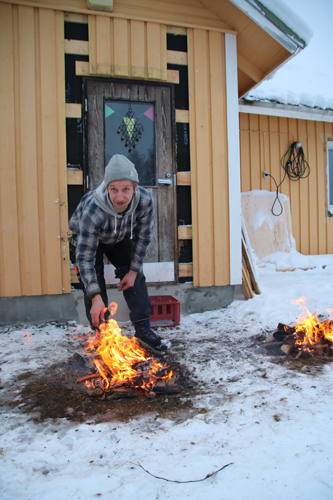Seppo Lempinen toivottaa tervetulotulilla vieraan tervetulleeksi, vaikka toki kyse on maan sulattamisesta kuistin rakentamista varten.