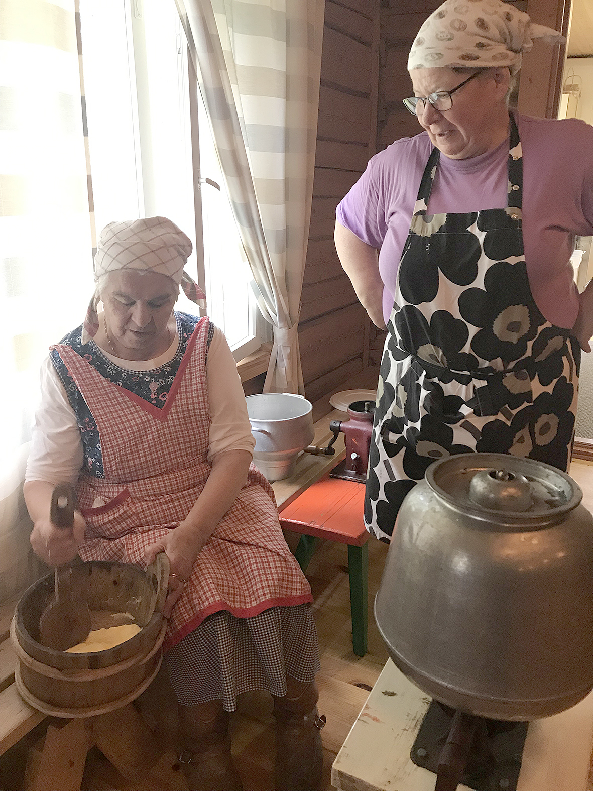 Perinteisessä emännän asussa Seija Martikainen suolaamassa voita ja Katri Kallinen ottamassa oppia. 