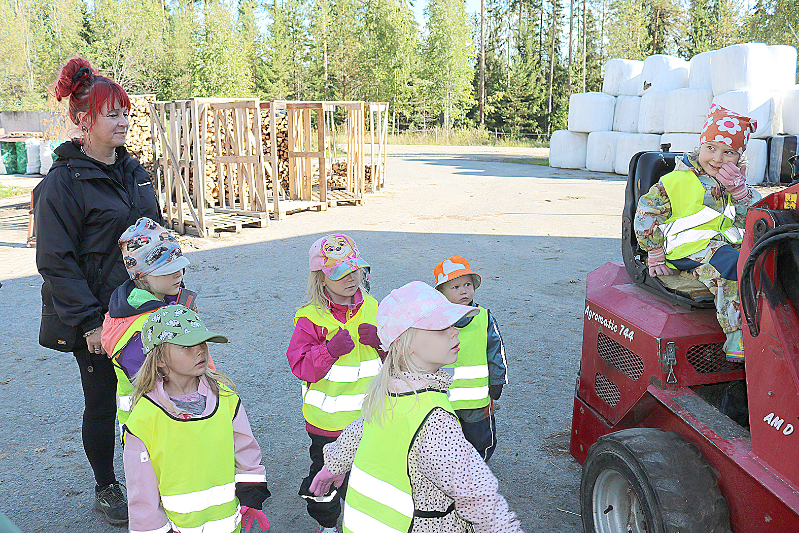 Varhaiskasvatuksen opettaja Eija Simonen luotsasi Ahmovaaran ryhmiksen lapsia. Pienkuormaajan kyydissä istuvaa Lili Flognya vähän hymyilyttää.