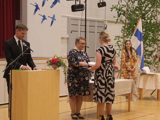 Saana-Maria Tuononen saa todistuksen ja ylioppilaslakin. Ne hänelle ojentaa lehtori Eija Gröhn-Syysjoki.